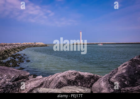 Querformat der Jetty von Ostende in Belgien, mit einem hellen Haus im Hintergrund und die riesigen Felsen im Vordergrund. Stockfoto