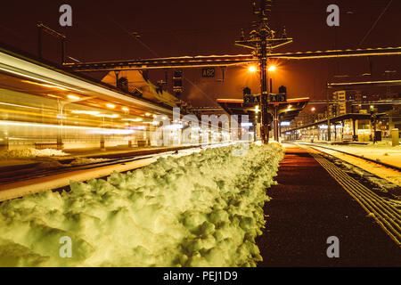 Lange Belichtung geschossen von einem Zug in die Station von Fribourg in der Schweiz, mit Schnee auf den Spuren Stockfoto