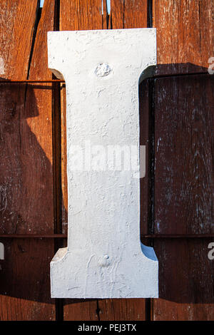 Große, weiße Buchstaben I auf dunklen Hintergrund die von der Sonne beleuchtet Stockfoto