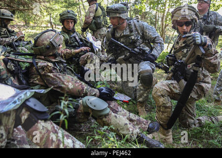 Ein US-Soldat von Alpha Company, 2.BATAILLON, 501 Infanterie Regiment, 1 Infanterie Brigade, 82nd Airborne Division und italienische Soldaten von der Ampel an der 183rd Parachute Regiment einander kurz vor Durchführung einer ausgebauten Patrouille während der Übung die schnelle Reaktion 15 bei der US Army Joint Multinational Readiness Center in Hohenfels, Deutschland, 26.08.2015. Der Zweck der Übung ist es, gemeinsame und kombinierte Ausbildung Veranstaltungen durchzuführen, um Brigade und Bataillon ebene Durchführung von Strategischen heraus - Belastung in Verbindung mit den alliierten Partner Nationen über eine zwischengeschaltete staging Basis zu bewerten. Swift R Stockfoto