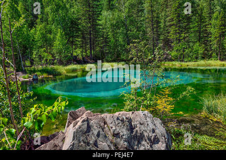 Amazing blue Geysir See in den Bergen des Altai, Russland. Einzigartige türkisfarbenen See mit kristallklarem Wasser und oval kreisenden Scheidungen, die sich ändern werden. Stockfoto