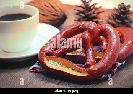 Brezel mit Kaffee auf Holz Tisch Stockfoto