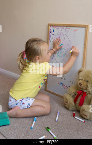 Junge zwei Jahre altes Mädchen Zeichnung mit Farbstift auf dem Whiteboard, künstlerischen, Stockfoto