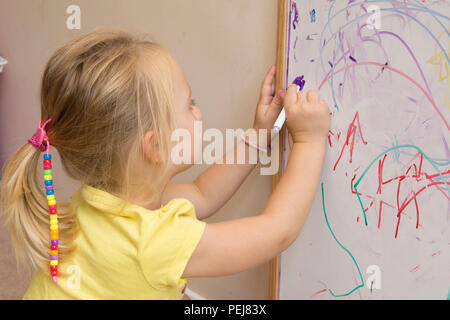 Junge zwei Jahre altes Mädchen Zeichnung mit Farbstift auf dem Whiteboard, künstlerischen, Stockfoto