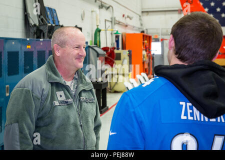 Brig. General John D. Slocum, der Commander, 127 Flügel, Selfridge Air National Guard Base, spricht mit Zach Zenner, ein Running back Für die Detroit Lions, vor einer Preisverleihung im Coast Guard Air Station Detroit Selfridge ANGB Nov. 23, 2015 statt. Slocum wurde an Hand für die Darstellung des Lieutenant Jack Rittichier Trophäe. (U.S. Coast Guard Foto von Petty Officer 3. Klasse Christopher M. Gieren) Stockfoto