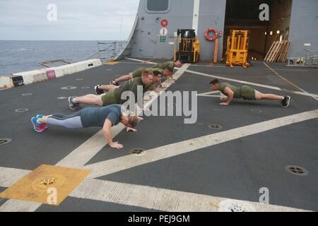 Pazifik (31. 7, 2015) US-Marines mit 1 leichten gepanzerten Aufklärer Loslösung, Bataillon Landung Team 3 Bataillon, 1. Marine Regiment, 15 Marine Expeditionary Unit, Übung mit Familienmitgliedern auf dem Flugdeck an Bord der USS Anchorage LPD (23). Die 15. MEU zu Ende Bereitstellung und ein Tiger Cruise für Familie Mitglieder hosting zur Schau zu stellen, das Leben an Bord der Verankerung. (U.S. Marine Corps Foto von Sgt. Steve H. Lopez/Freigegeben) Stockfoto