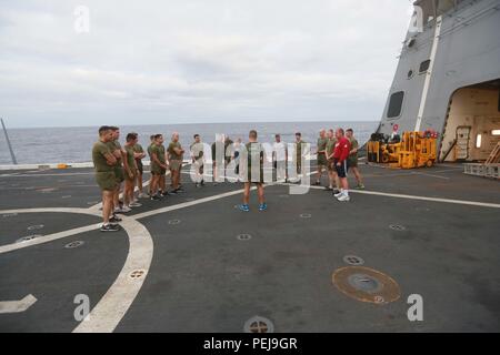 Pazifik (31. 7, 2015) US-Marines mit 1 leichten gepanzerten Aufklärer Loslösung, Bataillon Landung Team 3 Bataillon, 1. Marine Regiment, 15 Marine Expeditionary Unit, Übung mit Familienmitgliedern auf dem Flugdeck an Bord der USS Anchorage LPD (23). Die 15. MEU zu Ende Bereitstellung und ein Tiger Cruise für Familie Mitglieder hosting zur Schau zu stellen, das Leben an Bord der Verankerung. (U.S. Marine Corps Foto von Sgt. Steve H. Lopez/Freigegeben) Stockfoto