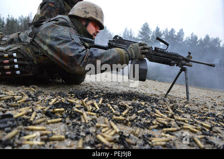 Ein deutscher Soldat feuert eine M249 Light Machine Gun während der Einarbeitung Training auf US-Waffen an der 7. Armee gemeinsame Multinationale Ausbildung Befehl Grafenwöhr Training Area, Deutschland, Dez. 9, 2015. (U.S. Armee Foto von visuellen Informationen Spezialist Gertrud Zach/freigegeben) Stockfoto