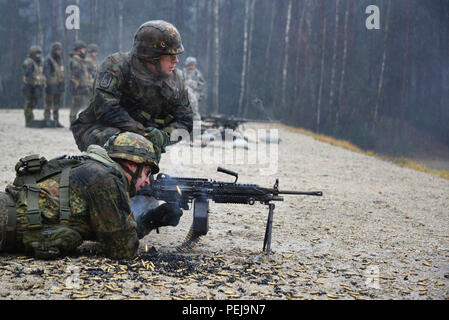 Ein deutscher Soldat feuert eine M249 Light Machine Gun während der Einarbeitung Training auf US-Waffen an der 7. Armee gemeinsame Multinationale Ausbildung Befehl Grafenwöhr Training Area, Deutschland, Dez. 9, 2015. (U.S. Armee Foto von visuellen Informationen Spezialist Gertrud Zach/freigegeben) Stockfoto