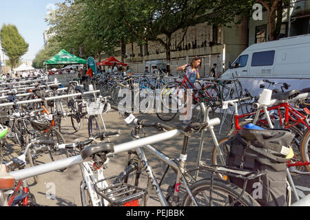 Fahrräder und Arbeiterin in einem freien und sicheren Fahrrad Fahrrad Parkplatz Parkservice, Vancouver, BC, Kanada Stockfoto