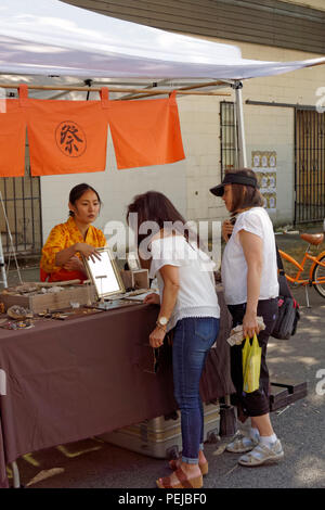 Eine japanische kanadische Frau, die beim jährlichen Powell Street Festival in Japantown, Vancouver, BC, Kanada, Schmuck verkauft Stockfoto