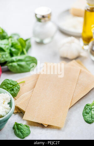 Zutaten für vegetarische Lasagne mit Spinat und Ricotta, grauer Hintergrund Stockfoto