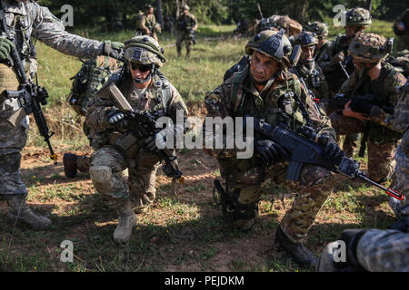 Ein US-Soldat von Alpha Company, 2.BATAILLON, 501 Infanterie Regiment, 1 Infanterie Brigade, 82nd Airborne Division und ein italienischer Soldat der 183Rd Parachute Regiment Monitor das Radio während der Durchführung einer ausgebauten Patrouille während der Übung die schnelle Reaktion 15 bei der US Army Joint Multinational Readiness Center in Hohenfels, Deutschland, 26.08.2015. Der Zweck der Übung ist es, gemeinsame und kombinierte Ausbildung Veranstaltungen durchzuführen, um Brigade und Bataillon ebene Durchführung von Strategischen heraus - Belastung in Verbindung mit den alliierten Partner Nationen über eine zwischengeschaltete staging Basis zu bewerten. Swift Stockfoto