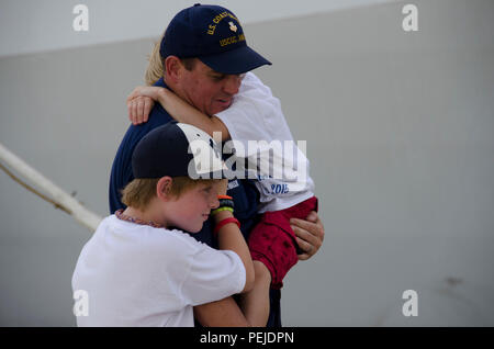 Ein United States Coast Guard Cutter James Besatzungsmitglied ist mit Familienangehörigen während der Eröffnungs-homecoming des Werkzeugs nach Charleston, S.C. Aug 28, 2015 wiedervereinigt. Die James ist der fünfte von acht geplanten nationalen Sicherheit Schneider - der größten und technologisch fortschrittlicher class Kutter in der Flotte der Küstenwache. (U.S. Air Force Foto/Staff Sgt. AJ Hyatt) Stockfoto