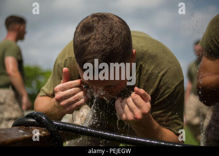 Marine Cpl. David B. Gale wäscht sein Gesicht nach Abschluss der OC-Spray Performance Evaluation Kurs auf Camp Hansen, Okinawa, Japan, August 27, 2015. Marines, Soldaten, Matrosen und Fliegern aus ganz Okinawa nahmen an der Non-Lethal Waffen Instructor Kurs, der nur einmal im Jahr zum Service Mitglieder auf der Insel angeboten. Gale aus Kennewick, Washington, ist eine Chemische, biologische, radiologische und nukleare Verteidigung Spezialist mit Sitz Bataillon, 3rd Marine Division, III Marine Expeditionary Force und die Sicherheiten in Höhe von nicht-tödlichen Waffen Kursleiter auf completi haben Stockfoto