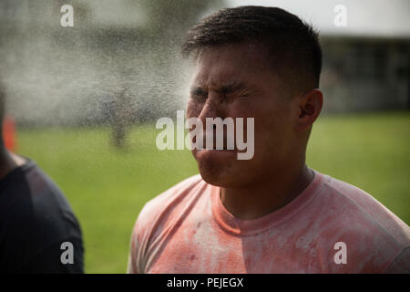 Army Staff Sgt. Nho T.Nguyen erhält mit OC während der OC-Spray Performance Evaluation Kurs auf Camp Hansen, Okinawa, Japan, Nov. 27, 2015 gesprüht. Die OC-Kurs ist ein Teil der Non-Lethal Waffen Instructor Kurs. Bevor die Kursteilnehmer Instructor Zertifizierung erwerben, Sie müssen sich selbst mit OC-spray vertraut machen und seine Auswirkungen aus erster Hand zu erleben. Nguyen, von Huntington Beach, Kalifornien, ist ein militärischer Polizist mit der im Militär Polizeiaufgebot und die Sicherheiten in Höhe von nicht-tödlichen Waffen Ausbilder nach Abschluss des Kurses haben. (U.S. Marine Corps Foto von Cpl. Thor La Stockfoto