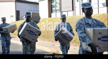 Staff Sgt. Jessica Gregor (links), Sgt. 1. Klasse Marcus Mitchell, Sgt. Maj. Michael Ledesma und Master Sgt. Addley Saimbert, alle Mitglieder der Rheinland-pfalz Kapitel der Sergeant Morales Club- und Unteroffiziersausbildung zum 21 Theater Sustainment Command, bewegen Sie Kisten und Möbel in Sembach Mittel- und Volksschulen Aug 26 zugeordnet. Der erste offizielle Tag der Schule für das Verteidigungsministerium Bildung Aktivität Studenten war 12.08.31. Stockfoto