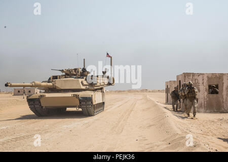 KUWAIT (28. August 2015) US-Marines mit Kilo Company, Battalion Landing Team 3. Bataillon, 1. Marineregiment, 15. Marine Expeditionary Unit, Proben urban patrouillierenden Techniken wie ein M1A1 Abrams-Panzer bietet Sicherheit bei militärischen Operationen in urbanem Gelände Training. Während der Ausbildung Marines geprobt patrouillieren durch Stadtgebiete und Sofortmaßnahmen Bohrer. Elemente des 15. MEU sind an Land in Kuwait für Erhaltung Ausbildung zu erhalten und zu verbessern die Fähigkeiten, die sie während ihrer Periode der Einsatzvorbereitenden Ausbildung entwickelt.  Die 15. MEU ist an Bord der Essex amphibische lesen begonnen. Stockfoto