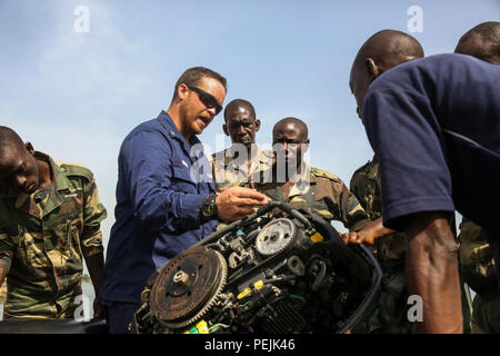 U.S. Coast Guard Petty Officer 3rd Class Errik Gordon, ein Ingenieur, erklärt Teile der Viertaktmotor und vorbeugende Wartung Grundlagen Während ein Boot Einarbeitung Klasse mit senegalesischen Compagnie Füsilier de Marin Kommandos in Dakar, Senegal, Nov. 28, 2015. Eine Zusammenarbeit im Bereich der Sicherheit Team von 21 Marinen und Küstenwache, mit special-purpose Marine Air-Ground Task Force Krise Response-Africa, eingesetzt in den Senegal mit der senegalesischen Armee ihre Interoperabilität durch Infanterie Taktik und kleinen Boot Operations Training zu verbessern und die Stärkung der Partnerschaft zwischen t Stockfoto