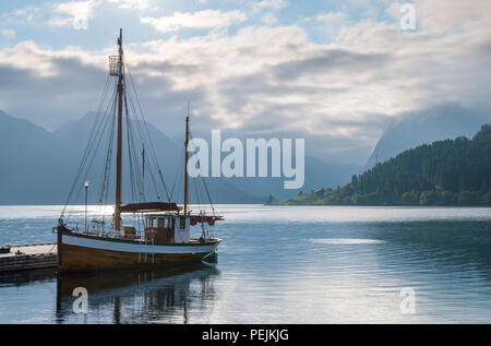 Norwegen Fjorde. Boot vertäut am Steg außerhalb der Sagafjord Hotel am frühen Morgen, Saebø, Hjørundfjord, Møre og Romsdal, Norwegen Stockfoto