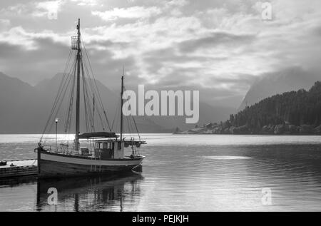 Norwegen Fjorde. Boot vertäut am Steg außerhalb der Sagafjord Hotel am frühen Morgen, Saebø, Hjørundfjord, Møre og Romsdal, Norwegen Stockfoto