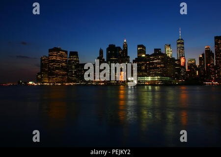 NEW YORK, NY - 03. Juli: Financial District, Lower Manhattan Skyline nach Sonnenuntergang wie aus Brooklyn Bridge Park, Brooklyn gesehen Stockfoto