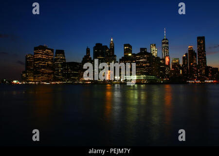 NEW YORK, NY - 03. Juli: Financial District, Lower Manhattan Skyline nach Sonnenuntergang wie aus Brooklyn Bridge Park, Brooklyn gesehen Stockfoto