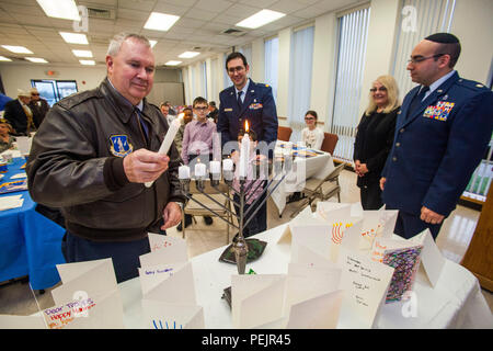 Brig. Gen. Michael L. Cunniff, Links, der Adjutant General von New Jersey, leuchtet eine der vier Kerzen auf der Menorah - Für jeden Tag von Hanukkah bei Kerzenschein Zeremonie an der Hauptbasis Kapelle, Joint Base Mc Guire-Dix - Lakehurst, New Jersey, Dez. 9, 2015. Die Veranstaltung wurde gemeinsam von der Hauptbasis Kapelle und Jüdische Kriegsveteranen Post 126 gefördert. Chanukka erinnert an die Umwidmung der Heilige Tempel in Jerusalem während der maccabean Revolte. Chanukka ist für acht Nächte und Tage beobachtet, beginnend mit dem 25. Kislew nach dem Hebräischen Kalender, die jederzeit vom späten N auftreten Stockfoto