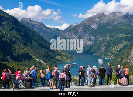 Geiranger, Norwegen. Touristen am Aussichtspunkt mit Blick auf die Stadt von Geiranger und Geirangerfjord, Norwegen Stockfoto