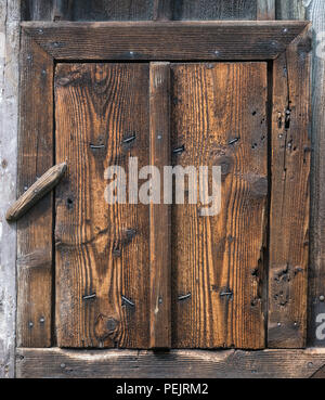 Geschlossene Holz- rustikalen Wicket, Revolvierenden sperren. Kleine ländliche Tür. Grob strukturierte Holz, Nägel, Knoten. Dorf Hintergrund des Jahrgangs Planken, Rahmen, fangen. Stockfoto