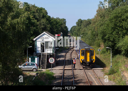 Der Network Rail signalgerät an Rainford sammelt die sinle Linie Token von der Nördlichen Rampe sprinter Zug auf einem Kirkby zu Wigan Zug Stockfoto