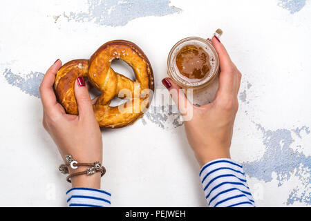 Helles Bier und Brezel in weibliche Hände Stockfoto