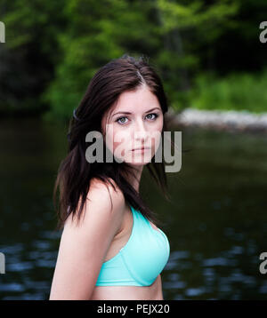 Porträt einer hübschen jungen Frau vor einem See posieren. Stockfoto