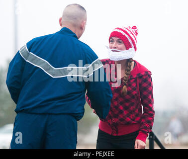 Us Air Force Oberstleutnant William Phillips (links), stellvertretender Kommandant für 43rd Luftbrücke Gruppe, gratuliert Kapitän Lorin Hoover, mit 43 Aeromedical Evacuation Squadron, als erste Frau die Ziellinie mit einem 5K-Laufzeit von 23:30 bei der jährlichen Spielzeug Trab Dez. 2, 2015, Fort Bragg, N.C. Die Rasse, die von 43 Luftbrücke Gruppe gefördert, wird verwendet, um neue, ausgepackten Spielwaren zur Unterstützung der 18. jährlichen Randy Oler Memorial Betrieb Spielzeug zu sammeln. (U.S. Armee Foto: Staff Sgt. Shaiyla Hakeem) Stockfoto