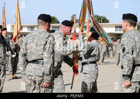 Command Sgt. Maj. Ted Copeland, command Sergeant Major des 79th Sustainment unterstützt den Befehl, vorbei an der 79th SSC guidon, Generalmajor Megan S. Tatu, 79th SSC's ausgehende Kommandierender General, während der Befehl Zeremonie am Joint Forces, Los Alamitos, Calif., Dez. 5, 2015. (U.S. Armee Foto von SPC. Heather Doppke/freigegeben) Stockfoto