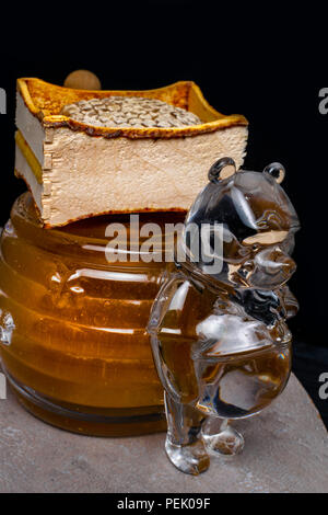 Honig im Glas container wie ein Bär, Honigwabe, Holzstab geformt Stockfoto