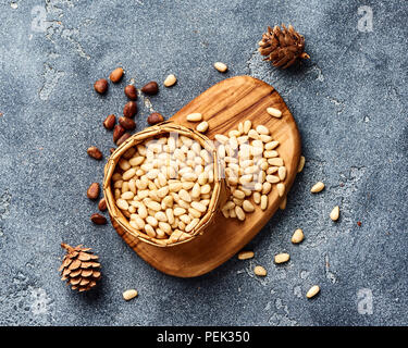 Kiefer geschälte Nüsse auf grauem Hintergrund. Ansicht von oben. Stockfoto