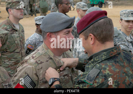 Us Air Force Master Sgt. Troy Misiak, 18 Air Support Betrieb Gruppe zugewiesen wurde, erhält Deutschen springen Flügel aus Deutschen jumpmaster Maj Daniel Labusch auf Luzon Drop Zone nach einem Betrieb für die 18. jährlichen Randy Oler Memorial Betrieb Spielzeug Fallen, bewirtet durch die US-Armee die zivilen Angelegenheiten & psychologische Operations Command (Airborne), im Camp Mackall, N.C., Dez. 9, 2015. Betrieb Spielzeug Drop ist der weltweit größte kombinierten Betrieb und gemeinsame Aus- und Fortbildung mit sieben Partner - nation Fallschirmjäger teilnehmenden und Soldaten erlaubt, die Möglichkeit, Kindern in Not zu helfen empfangen Stockfoto