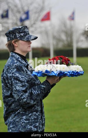 U.S. Navy Seaman Sydney, US Africa Command division Analyst, hält einen Kranz konzipiert als Anker der gefallenen Helden von Pearl Harbor während der 74Th Pearl Harbor Gedenkfeier an RAF Molesworth, Großbritannien, 7. Dezember 2015 zu Ehren. Pearl Harbor Überlebenden, ehemalige Marine Sgt. John Egan und US-Armee Oberst Mark Kjorness, USAFRICOM Joint intelligence Director, trat in Sydney Ehrenkompanie der Kranz, nachdem es platziert wurde. (U.S. Air Force Foto: Staff Sgt. Ashley Tyler/Freigegeben) (Name aus Sicherheitsgründen entfernt) Stockfoto