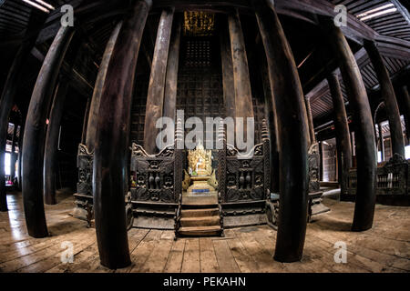 INWA (AVA), Myanmar - der Hauptaltar und Schrein des Bagaya-Klosters in Inwa, Myanmar. Das Kloster, auch bekannt als Bagaya Kyaung, wurde 1834 während der Herrschaft von König Bagyidaw erbaut. Er besteht vollständig aus Teakholz, mit 267 riesigen Teakholzpfählen, von denen der größte 60 m hoch und 9 m Umfang ist. Es liegt in der alten königlichen Hauptstadt von Inwa (Ava), nicht weit von Mandalay. Stockfoto