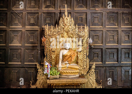 INWA (AVA), Myanmar - der Hauptaltar und Schrein des Bagaya-Klosters in Inwa, Myanmar. Das Kloster, auch bekannt als Bagaya Kyaung, wurde 1834 während der Herrschaft von König Bagyidaw erbaut. Er besteht vollständig aus Teakholz, mit 267 riesigen Teakholzpfählen, von denen der größte 60 m hoch und 9 m Umfang ist. Es liegt in der alten königlichen Hauptstadt von Inwa (Ava), nicht weit von Mandalay. Stockfoto