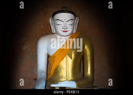Thisa-Wadi Tempel Buddha Statue Bagan Myanmar // BAGAN, Myanmar — Eine große Buddha-Statue besetzt den zentralen Schrein des thisa-Wadi Tempels (auch bekannt als Thissa-Wadi Tempel), eines von vier Buddha-Bildern, die um eine quadratische zentrale Säule angeordnet sind, jede in Richtung Kardinal gerichtet. Nach epigraphischen Beweisen aus dem Jahr 1334 n. Chr. stellt dieser dreistöckige Tempel eine der letzten großen Bauwerke der postheidnischen Zeit dar, die fast ein halbes Jahrhundert nach dem Fall des heidnischen Königreichs errichtet wurde. Der Tempel ist als Monument Nr. 918 in Pierre Pichards umfangreichem archäologischem Inventar der katalogisiert Stockfoto