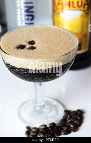 Espresso Martini mit Zutat Flaschen im Hintergrund Stockfoto