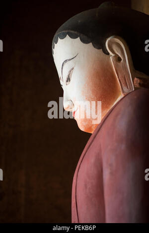 Thisa-Wadi Tempel Buddha Statue Bagan Myanmar // BAGAN, Myanmar — Eine große Buddha-Statue besetzt den zentralen Schrein des thisa-Wadi Tempels (auch bekannt als Thissa-Wadi Tempel), eines von vier Buddha-Bildern, die um eine quadratische zentrale Säule angeordnet sind, jede in Richtung Kardinal gerichtet. Nach epigraphischen Beweisen aus dem Jahr 1334 n. Chr. stellt dieser dreistöckige Tempel eine der letzten großen Bauwerke der postheidnischen Zeit dar, die fast ein halbes Jahrhundert nach dem Fall des heidnischen Königreichs errichtet wurde. Der Tempel ist als Monument Nr. 918 in Pierre Pichards umfangreichem archäologischem Inventar der katalogisiert Stockfoto