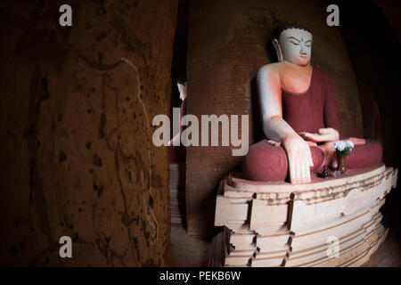 Buddha-Statuen Bagan Myanmar // BAGAN, Myanmar — Buddha-Statuen, die um eine zentrale Säule angeordnet sind, zeigen die vier Himmelsrichtungen im Inneren des thisa-Wadi Tempels (auch bekannt als Thissa-Wadi Tempel), einem dreistöckigen Tempel aus dem Jahr 1334 n. Chr. Der Tempel wurde in der postkaiserlichen Zeit, fast fünfzig Jahre nach dem Fall des heidnischen Königreichs, errichtet und demonstriert die Fortsetzung buddhistischer Architekturtraditionen trotz politischer Zersplitterung. Im südöstlichen Teil der archäologischen Zone Bagan gelegen, stellt dieses Wadi eines der letzten großen Tempelkonstruktionen dar Stockfoto