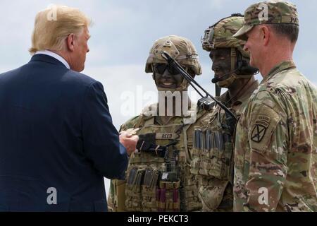 Us-Präsident Donald Trump ist ein 10 Combat Aviation Brigade Herausforderung Münze nach einem Luftangriff und Gun regen Demonstration bei einem Besuch der John McCain National Defense Authorization Act, den 13. August in Fort Drum, New York 2018 zu unterzeichnen. Stockfoto