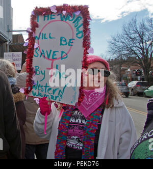 Asheville, NC, USA - Januar 20, 2018: eine Frau trägt einen Pussyhat hält ein politisches Signal: "Die Welt wird gerettet durch die westliche Frau'. Stockfoto