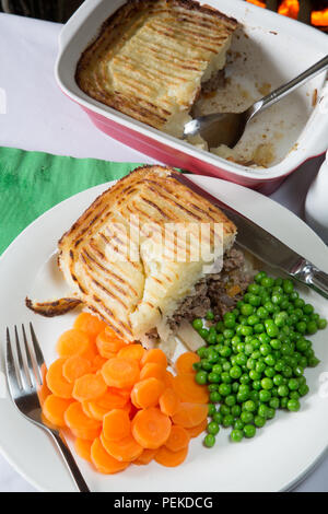 Ein englisches Pub/Restaurant traditionelle Cottage Pie serviert mit Möhren und Erbsen Stockfoto