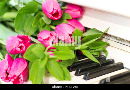 Rosa Tulpen und Notizen. Rosa Tulpen auf weißes Klavier Stockfoto