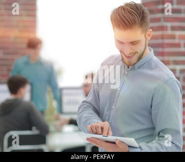 Bild von einem inspirierten Geschäftsmanns, der auf einem Tablet-PC im Büro, Stockfoto